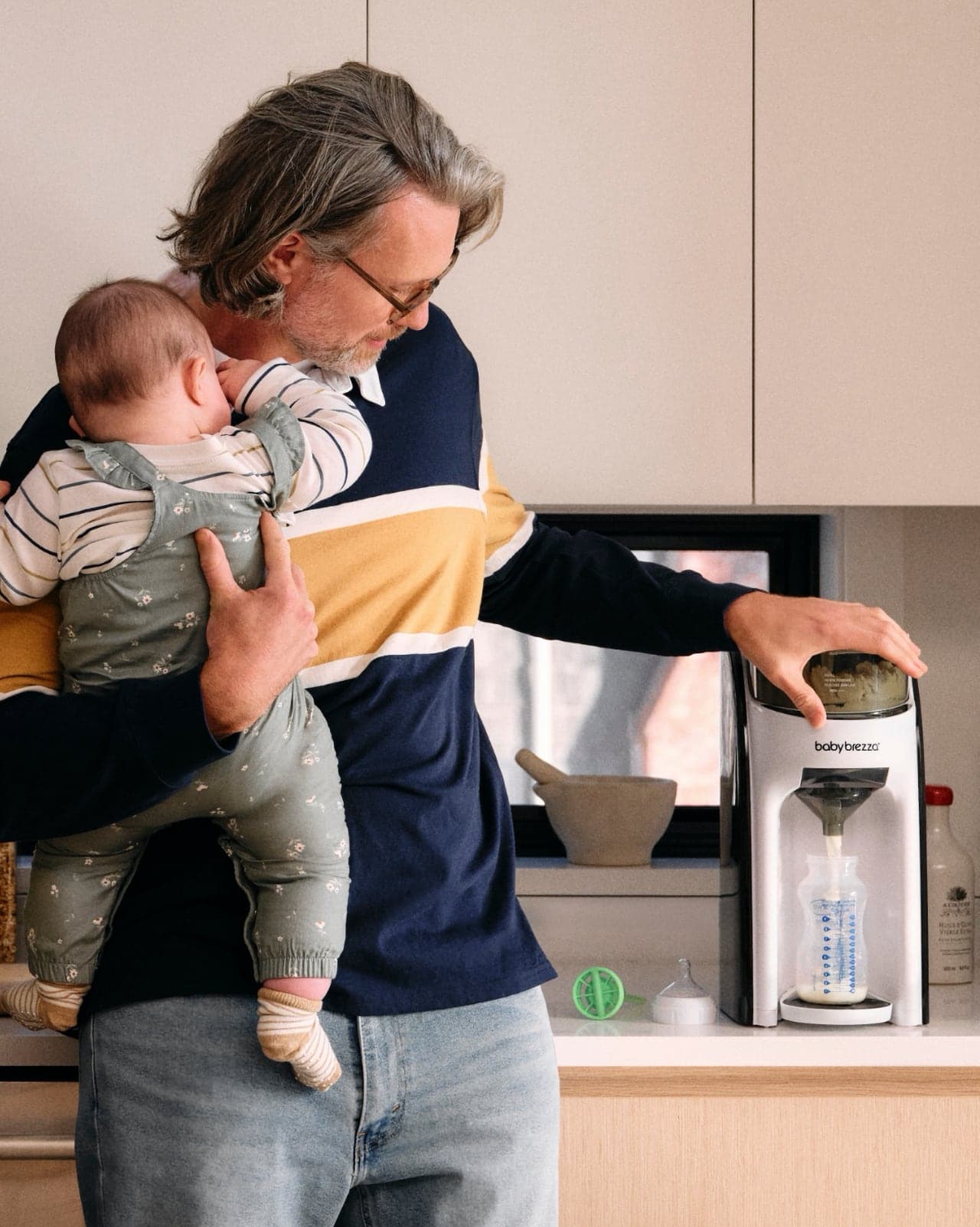Parents with Baby Brezza device, warm daylight